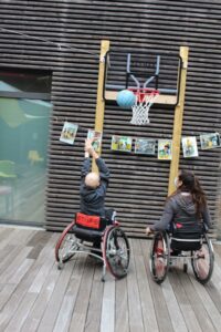 2 jeunes collégiens pendant une sensibilisation au basket fauteuil